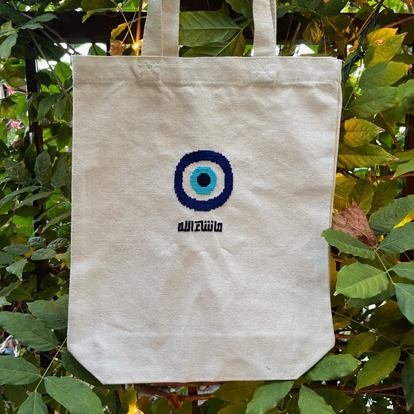 Finished tatreez tote bag kit with evil eye design. beige tote bag, view from the front