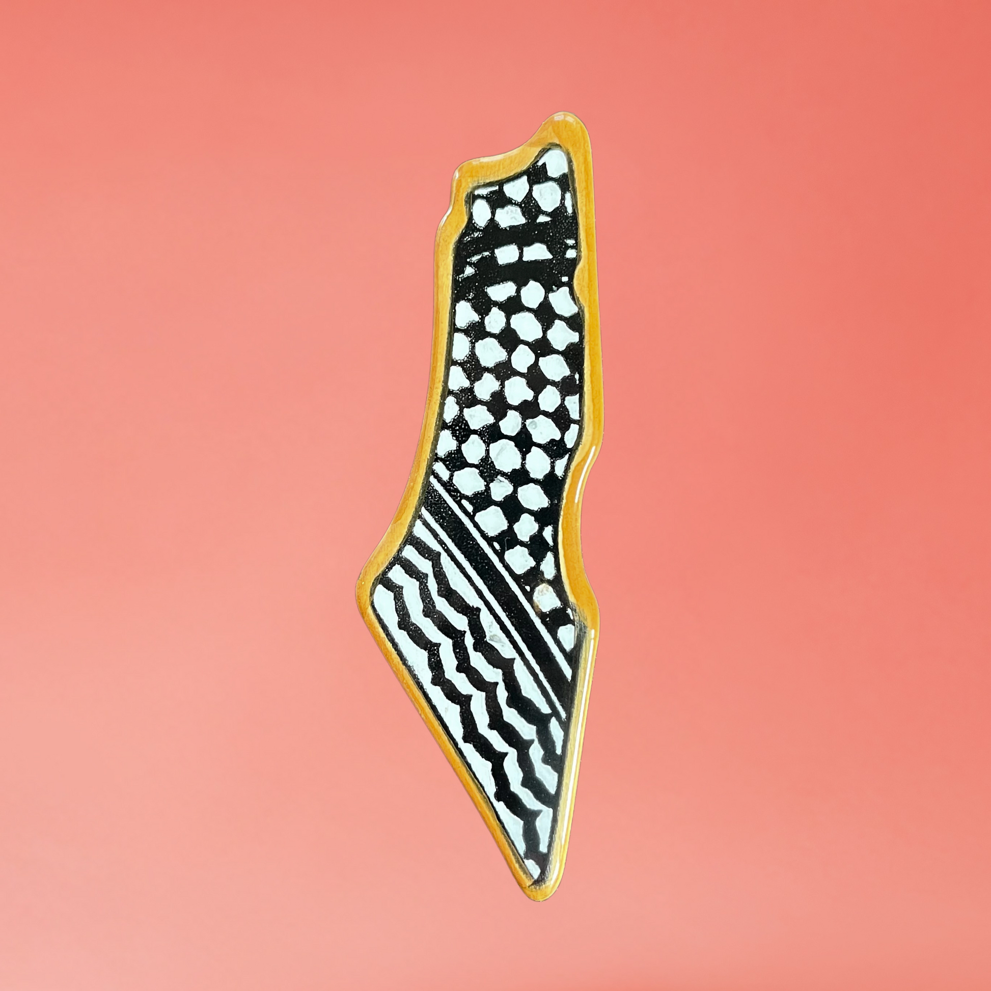 Ceramic Palestine map fridge magnet with orange kuffiyeh design. front view on pink background