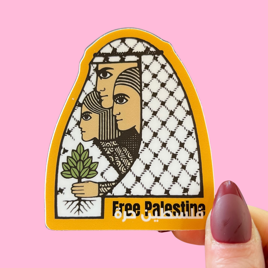 close-up of fingers holding a sticker with an image of a Palestinian family wrapped in a kuffiyeh and holding an olive tree. against a pink background