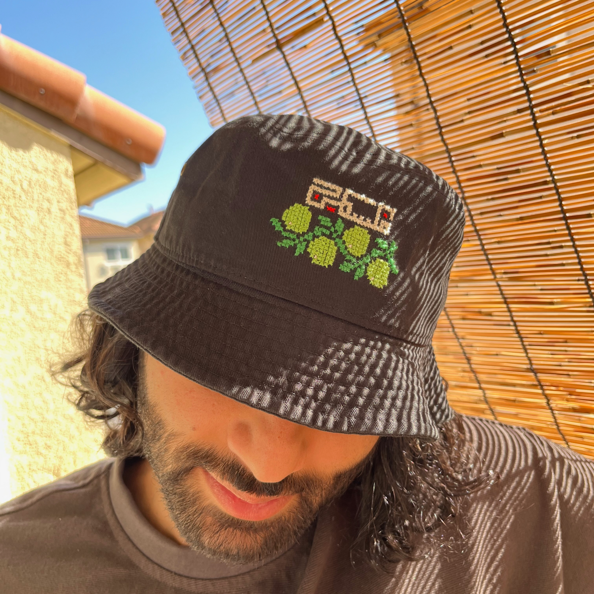 Model wearing finished olive and palestine bucket hat kit. view from the front