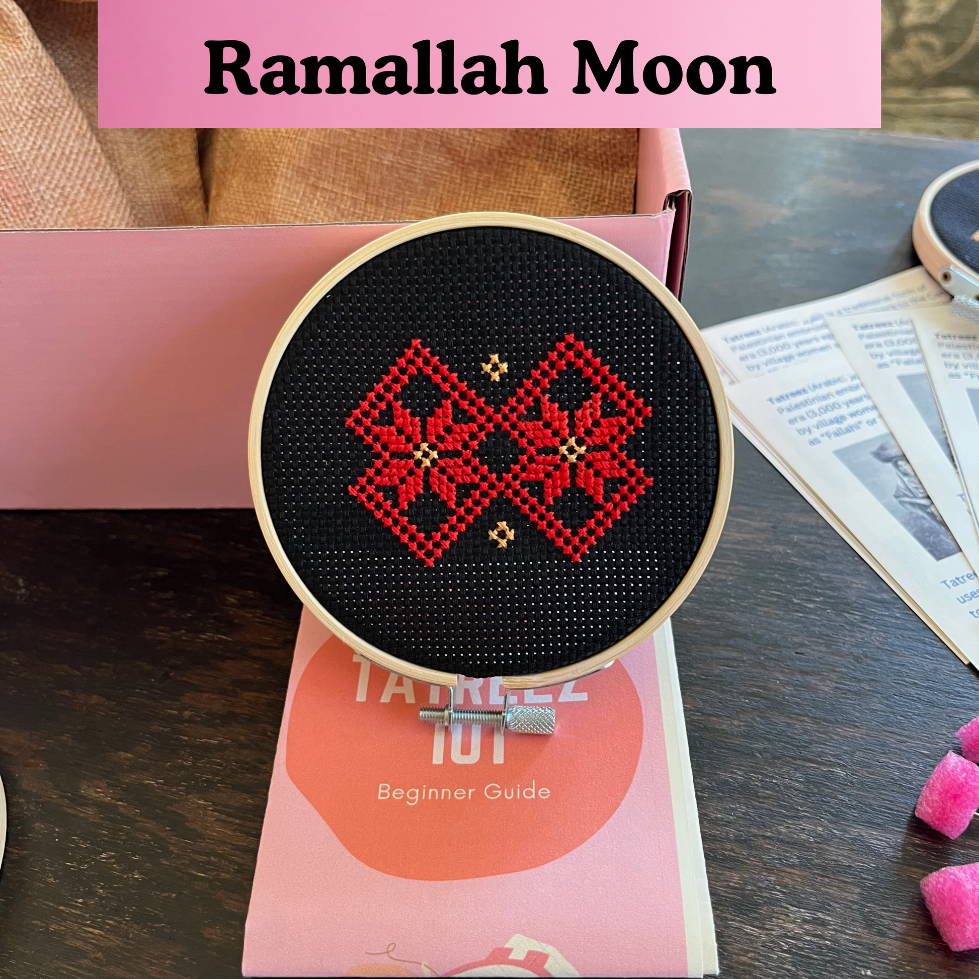 finished tatreez hoop kit with ramallah star moon design on black aida cloth. view from the front
