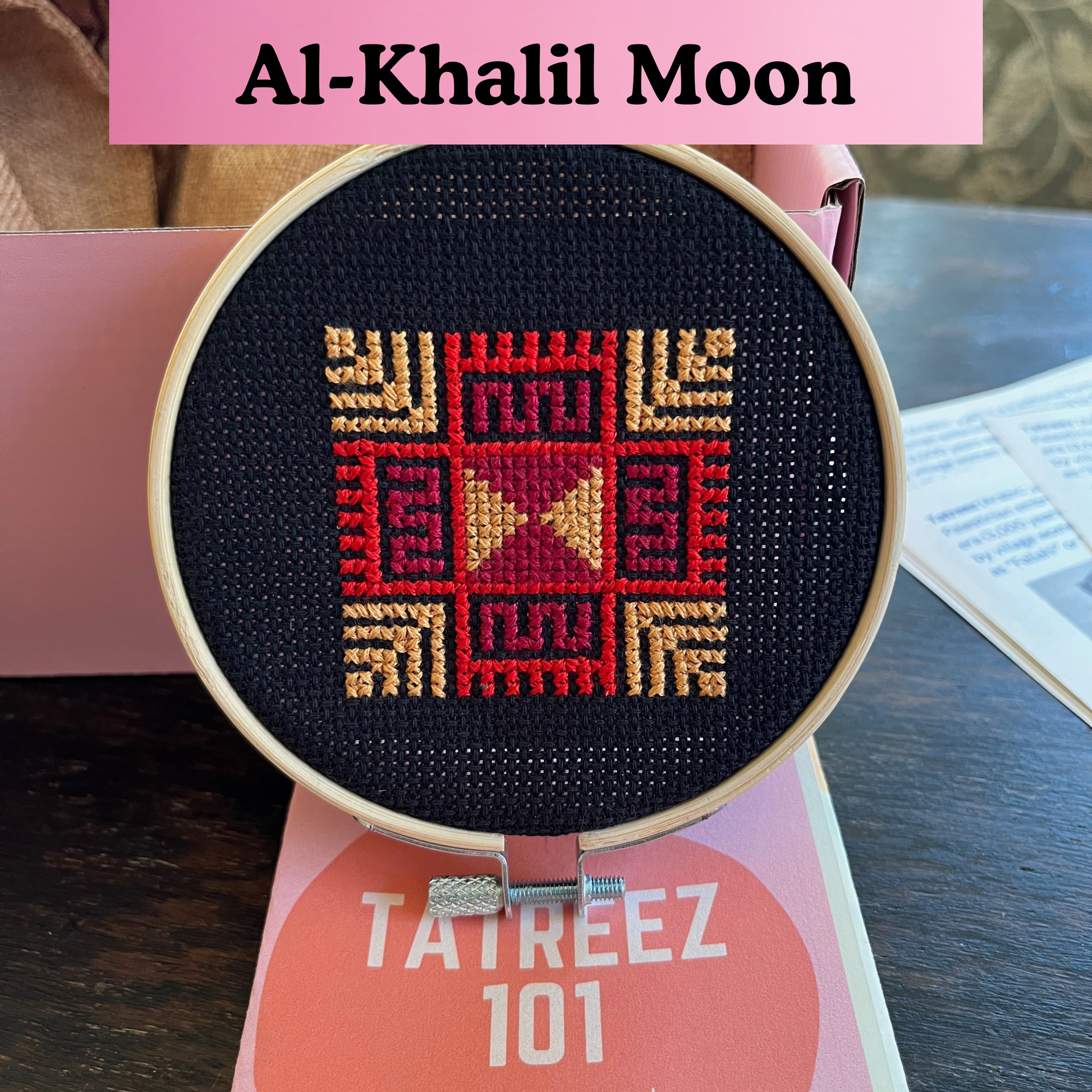 finished tatreez hoop kit with al-khalil moon with feathers design on black aida cloth. view from the front