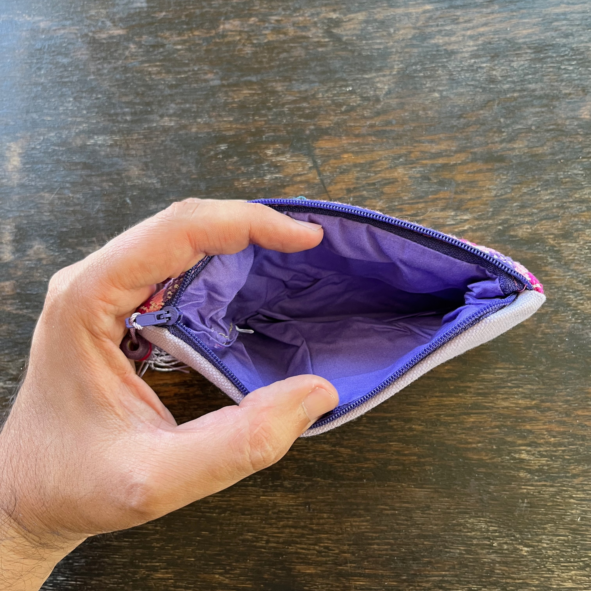 inside view from above of Palestinian tatreez embroidered purse/wallet/clutch bag. red, pink, and purple star moon design.