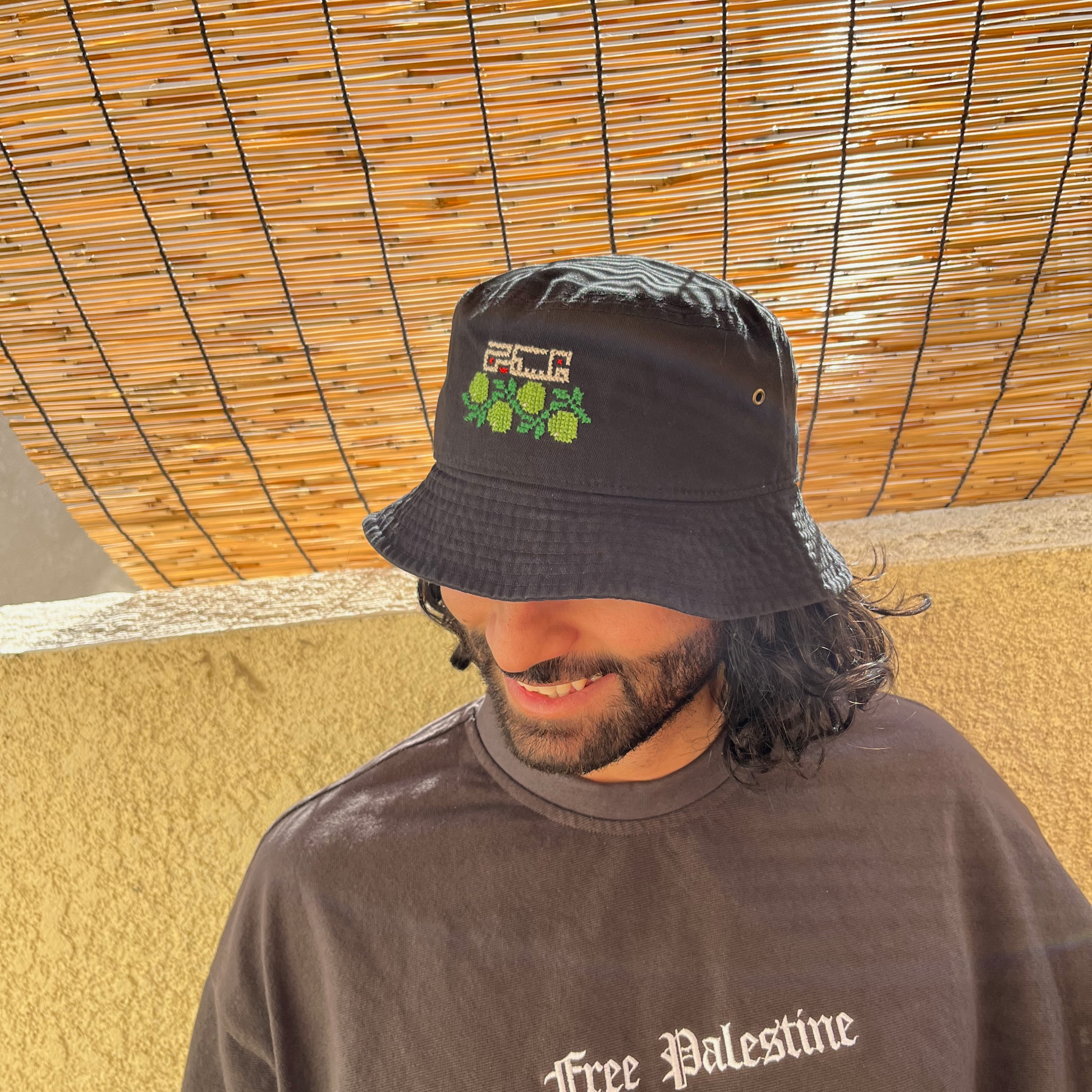 Model wearing finished olive and palestine bucket hat kit. view from the side