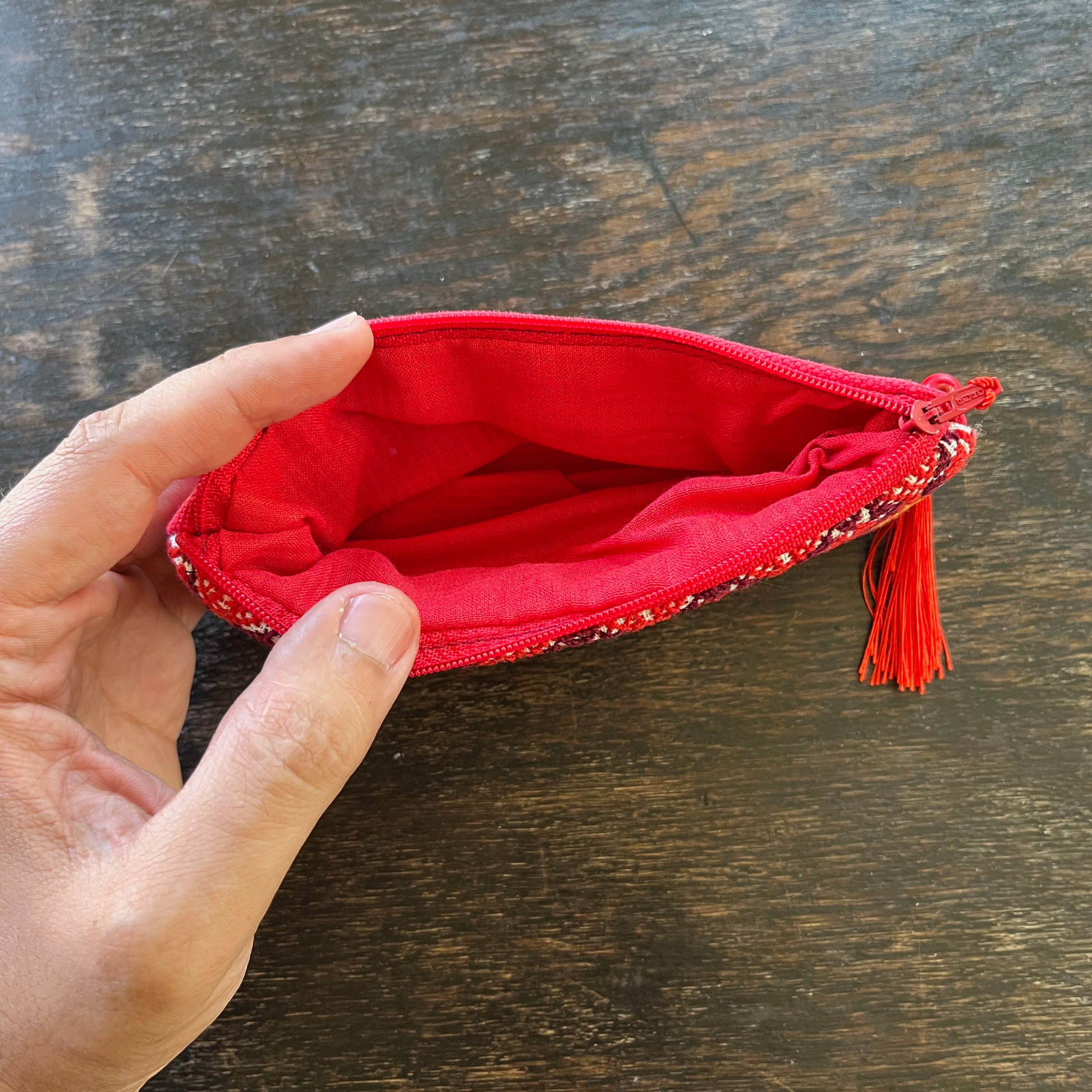 inside view from above of Palestinian tatreez embroidered purse/wallet/clutch bag. red, yellow, and purple star moon design.