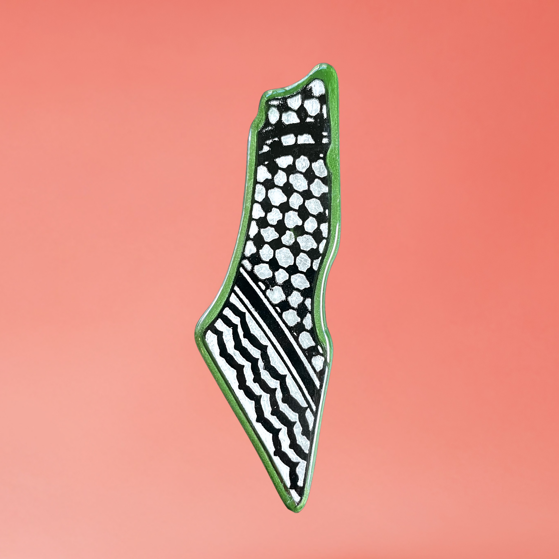 Ceramic Palestine map fridge magnet with green kuffiyeh design. front view on pink background