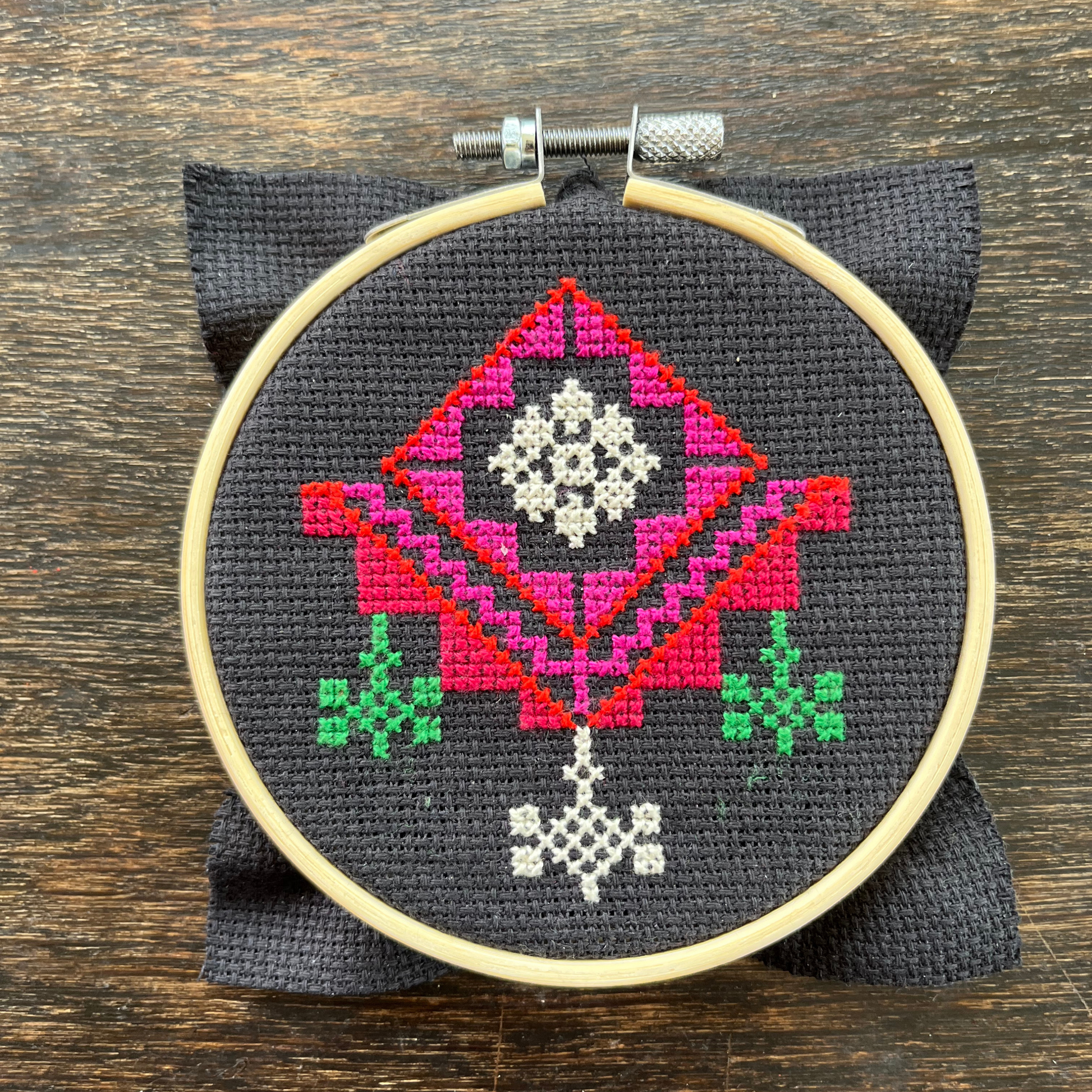 Tatreez kit with the al-khalil chandelier design. black aida cloth in embroidery hoop. view from above