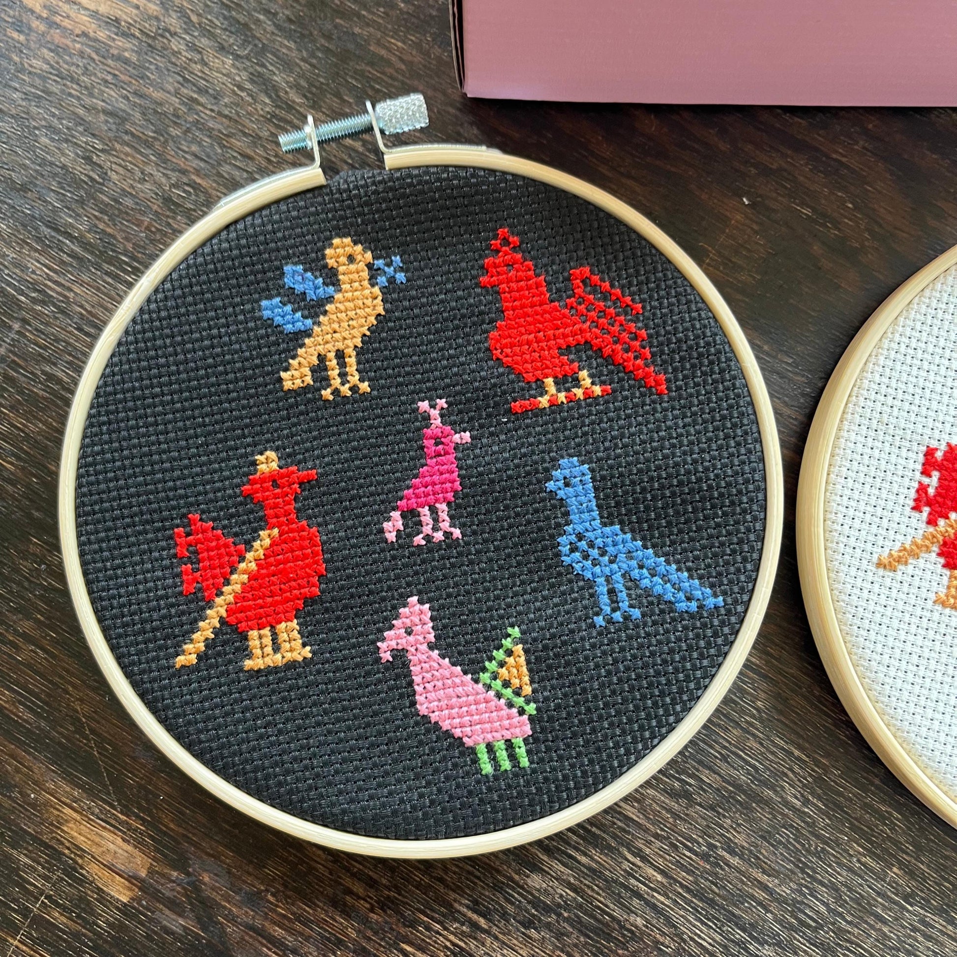 Tatreez kit with the birds of Ramallah design. black aida cloth in embroidery hoop. view from above